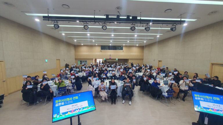 파주시 신청사 건립 공론화 토론회 현장 — 시민참여단이 참여 카드를 들어 보이는 모습